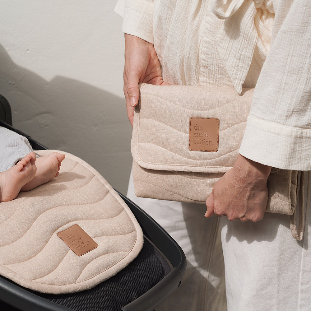 Close up of a Woman holding a change mat and Baby in a Pram