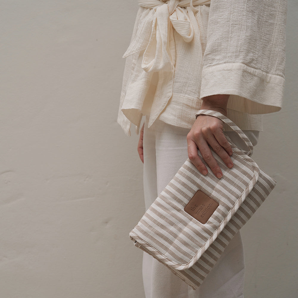 Close up of a woman holding a striped bag